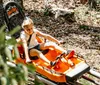 A child is enjoying a ride in an orange mountain coaster among the trees