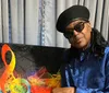 The image features a person wearing sunglasses and a hat posing in front of stylized text and colorful abstract graphics related to music with Stevie Wonder  More Soul written in a vibrant font