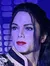 A person is posing for a playful photo with a lifelike wax figure of Michael Jackson.