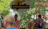 Audience members are seated on benches enjoying a live music performance by two musicians at Silver Dollar City.