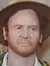 The image displays a life-sized figure of an adventurer dressed in iconic explorer gear, including a fedora hat, a leather jacket, and carrying a satchel, evoking the classic aesthetic of the intrepid archaeologist protagonist from a well-known film franchise.