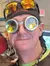 Two individuals are smiling for the camera while wearing whimsical goggles and hats inside a store.
