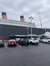 A parking lot full of cars with a large ship structure in the background that resembles part of the historic RMS Titanic.