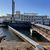A riverboat is docked at a pier with a walkway leading from the shore to the boat.