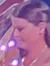 A woman in an elegant gown plays a harp on a foggy, colorful stage.