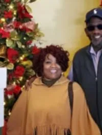 A couple poses in front of a festive display with Christmas trees and a stack of large gift boxes at the Showboat Branson Belle.