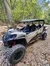 A rugged off-road vehicle is parked on a rocky trail in a forested area.