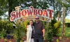 A couple is smiling and posing in front of a sign that reads