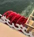 The image shows a red paddlewheel on a riverboat, partially submerged in moving water.