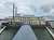 The image shows a large paddlewheel riverboat docked at a pier under a cloudy sky.
