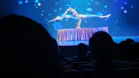 Two performers are doing an impressive acrobatic pose on stage under blue lighting.