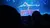 Two performers are doing an impressive acrobatic pose on stage under blue lighting.