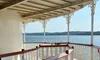 The image shows a shaded deck area on a boat with ornate white railings and a view of a calm body of water in the background.