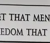 The image is a sign with the message emphasizing the importance of remembering those who died for freedom.