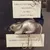 The image shows a vintage mouse-shaped fishing lure displayed with accompanying labels detailing its origin and date.