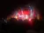 A live musical performance is taking place on stage with colorful lighting and an audience watching in the foreground.