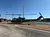A military helicopter is displayed in a parking lot with American flags and clear skies in the background.