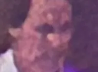 A lively stage performance featuring a man in an orange suit and a woman in an orange dress singing, with musicians playing instruments around them.