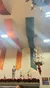 The image features a room with colorful draped banners, a knight statue, decorative reindeer, festive red ornaments, and a chandelier.