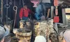 A blacksmith in a red shirt works at Shad's Forge while a group of people watch.