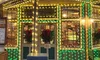 The image shows a warmly lit bakery decorated with festive lights and wreaths in the evening.