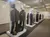 The image shows a museum display featuring a row of military uniforms and memorabilia in glass cases.