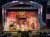 A lively musical performance is taking place on a decorated stage with performers in colorful costumes entertaining a seated audience.