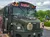The image shows a customized bus painted in a camouflage pattern with large longhorns mounted on the front, labeled 