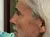 A man with long gray hair is pointing at a vintage 