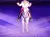 A person dressed in a cowboy outfit is riding a white horse in a spotlight on a purple-lit arena stage.