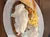 A plate containing chicken fried steak with white gravy, creamed corn, mashed potatoes, and a slice of toasted bread.