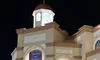 The image shows a well-lit building at night with a banner that reads 