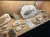 The image shows a display case containing various fish fossils and rock specimens, labeled and arranged on a cork background.