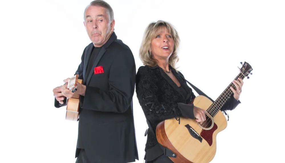 A man and a woman are playfully posing back to back each holding a stringed instrument with the man appearing surprised or cheeky and the woman smiling and singing