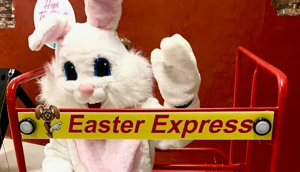 A person in an Easter Bunny costume is sitting on the Easter Express train ride