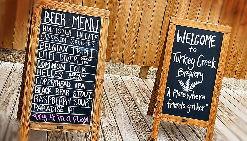 The image shows two sandwich board signs with one displaying a beer menu for a brewery and the other welcoming visitors to Turkey Creek Brewery described as A place where friends gather