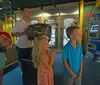 A family is engaged in an interactive exhibit with adults and children focused on an activity at a table