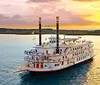 A large multi-story riverboat decorated with banners sails on a peaceful lake at sunset with an inset image showcasing a meal of roast mashed potatoes vegetables and dessert