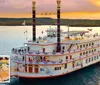 A large multi-story riverboat decorated with banners sails on a peaceful lake at sunset with an inset image showcasing a meal of roast mashed potatoes vegetables and dessert