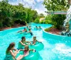 A group of people are enjoying a ride on an inflatable raft down a water slide with an inset showing a person smiling on a single-person tube