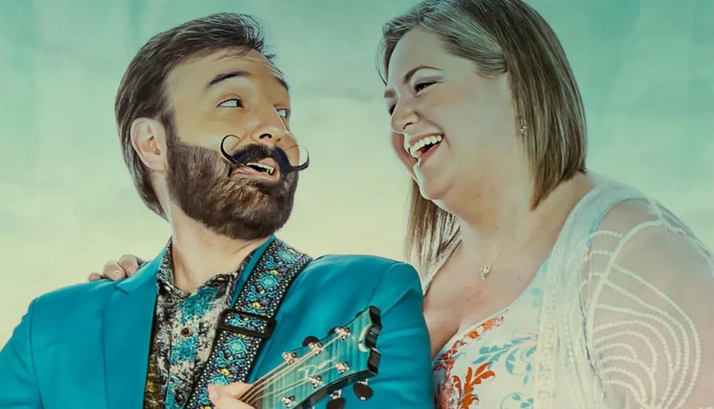 A man with a handlebar mustache in a patterned blazer holds a ukulele and shares a joyful moment with a woman laughing beside him against a pastel background