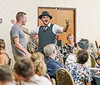 A lively dinner show scene with an engaging performer and guests enjoying their meals accompanied by positive reviews praising the food entertainment and service