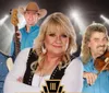 A group of musicians wearing cowboy hats and holding instruments pose confidently with spotlights in the background