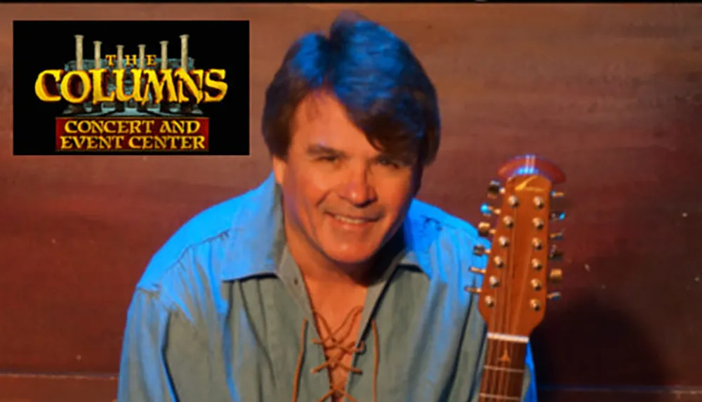 A person with a guitar is smiling next to a logo for The Columns Concert and Event Center