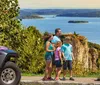 A pink Jeep is navigating a rocky off-road terrain amidst trees and rough slopes