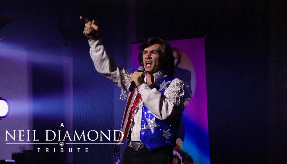 A performer dressed in a sequined vest with stars and stripes passionately sings into a microphone during a Neil Diamond tribute show