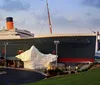 The image shows a large replica of the Titanic ship complete with an iceberg outside the Titanic Museum Attraction with a sign indicating NOW BOARDING 9am - 9pm