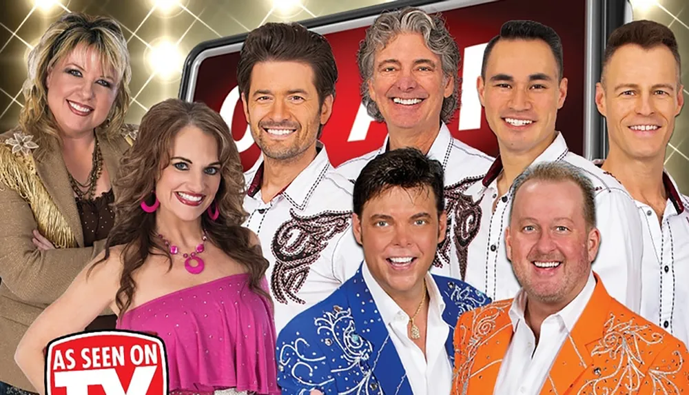 This image features a group of eight smiling people in colorful clothing posed together with an As Seen on TV graphic suggesting they might be part of a television show or advertisement