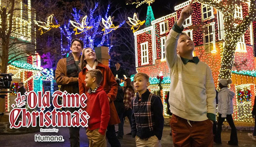 A family gazes up at festive Christmas lights and decorations in a brightly lit street during an event called An Old Time Christmas presented by Humana