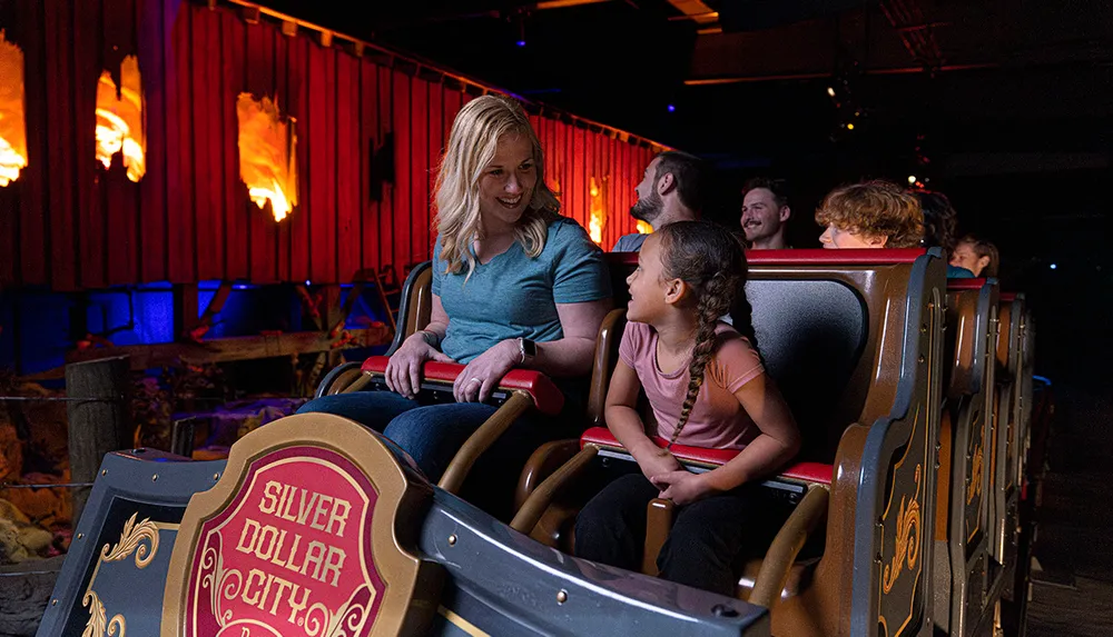 A group of people including a woman and a child are enjoying a ride at Silver Dollar City